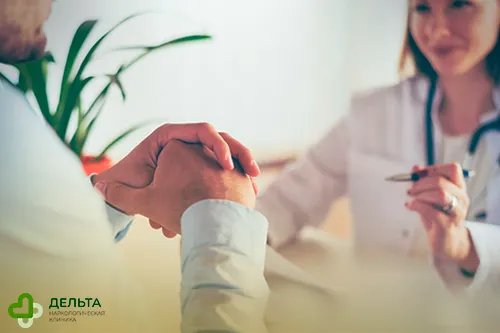 Мужчина сидит на против врача за столом